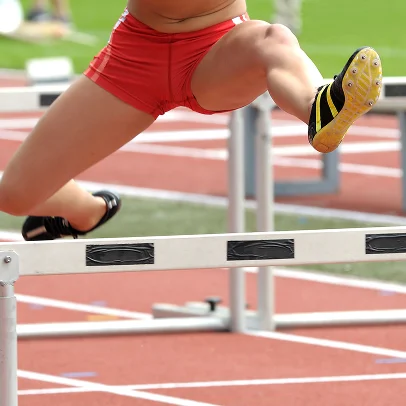 Une athlète en short rouge franchit une haie sur une piste d'athlétisme à Salbris en Loir-et-Cher 41