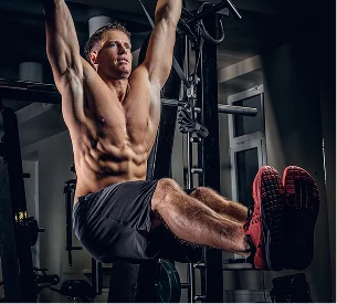 Un homme musclé fait des tractions, les jambes pliées et les abdominaux contractés à Salbris en Loir-et-Cher 41