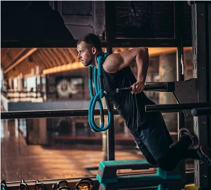 Homme musclé faisant des dips sur une barre, avec une corde bleue autour du cou à Salbris en Loir-et-Cher 41